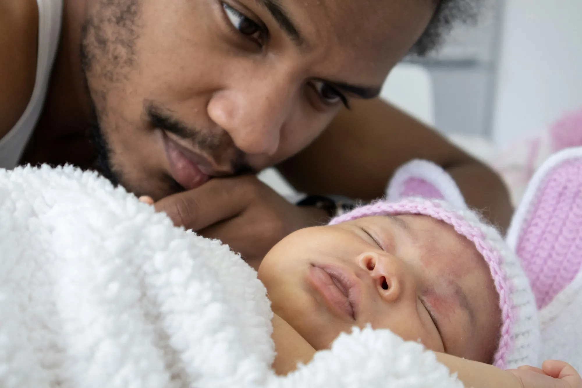 Father kissing his newborn daughter's forehead