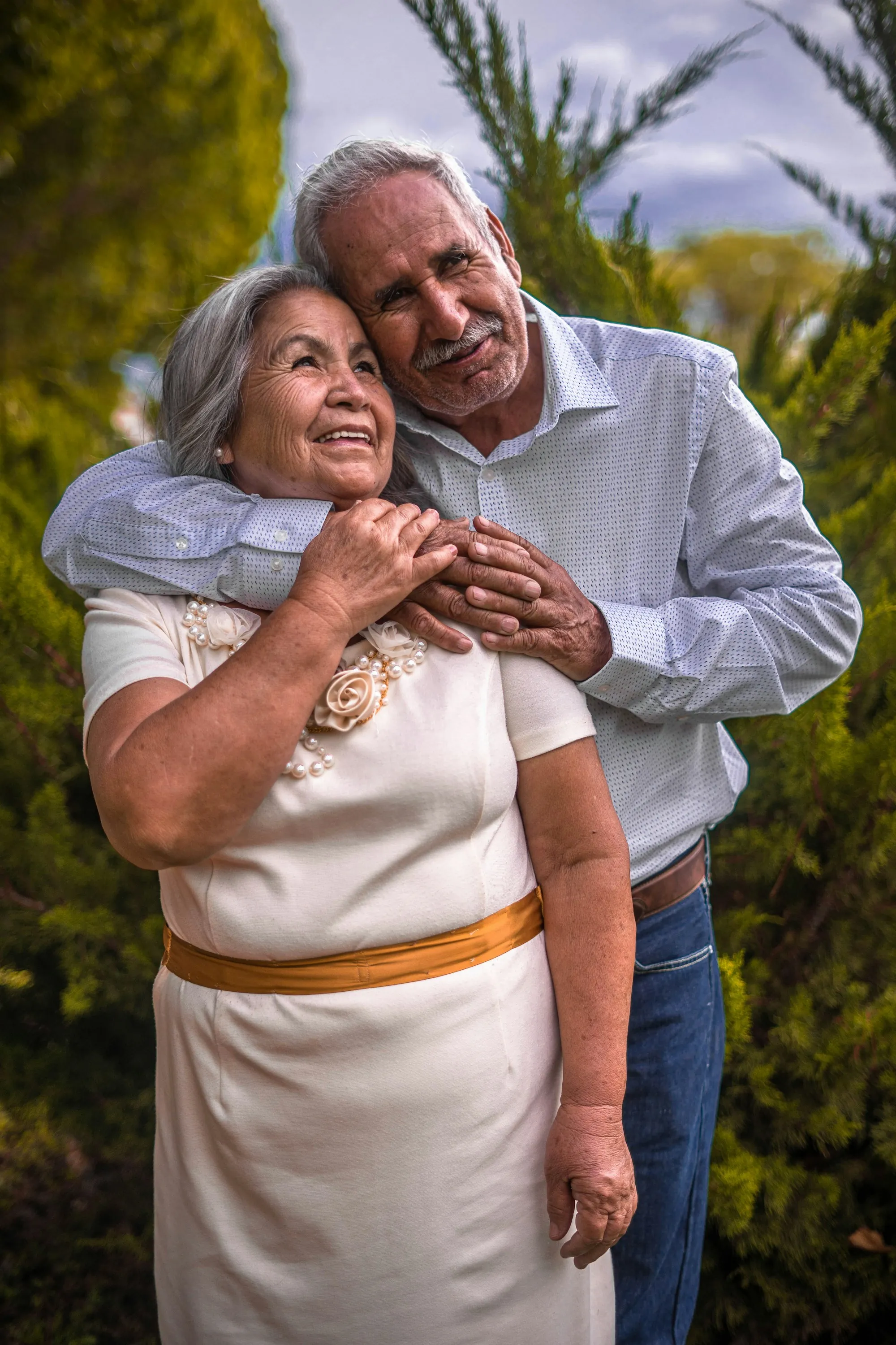 Senior man hugging his wife from behind outdoors